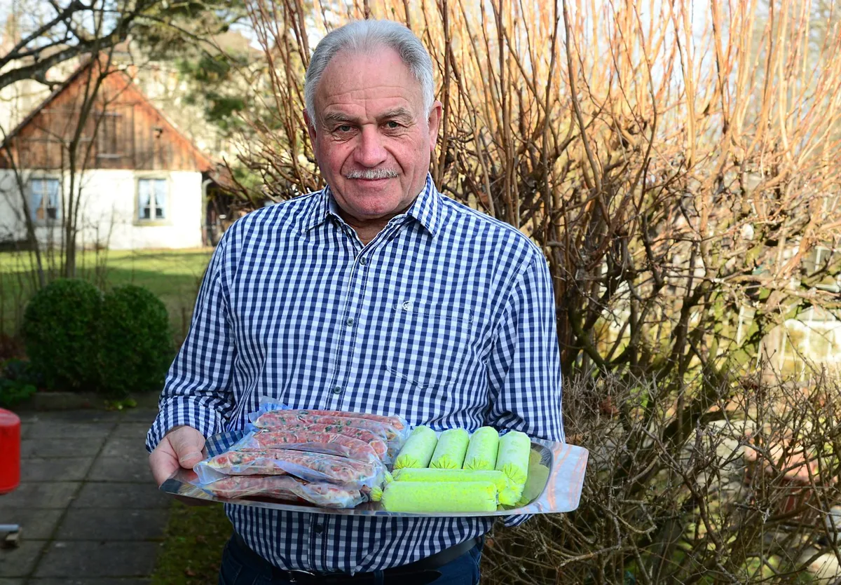 Mann mit Würsten auf einem Brett.